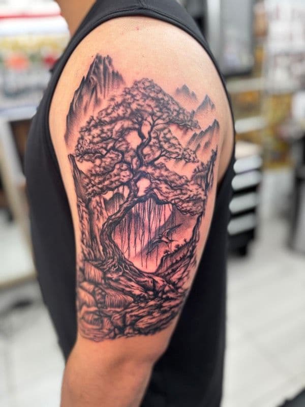 Black and grey Japanese landscape tattoo on upper arm